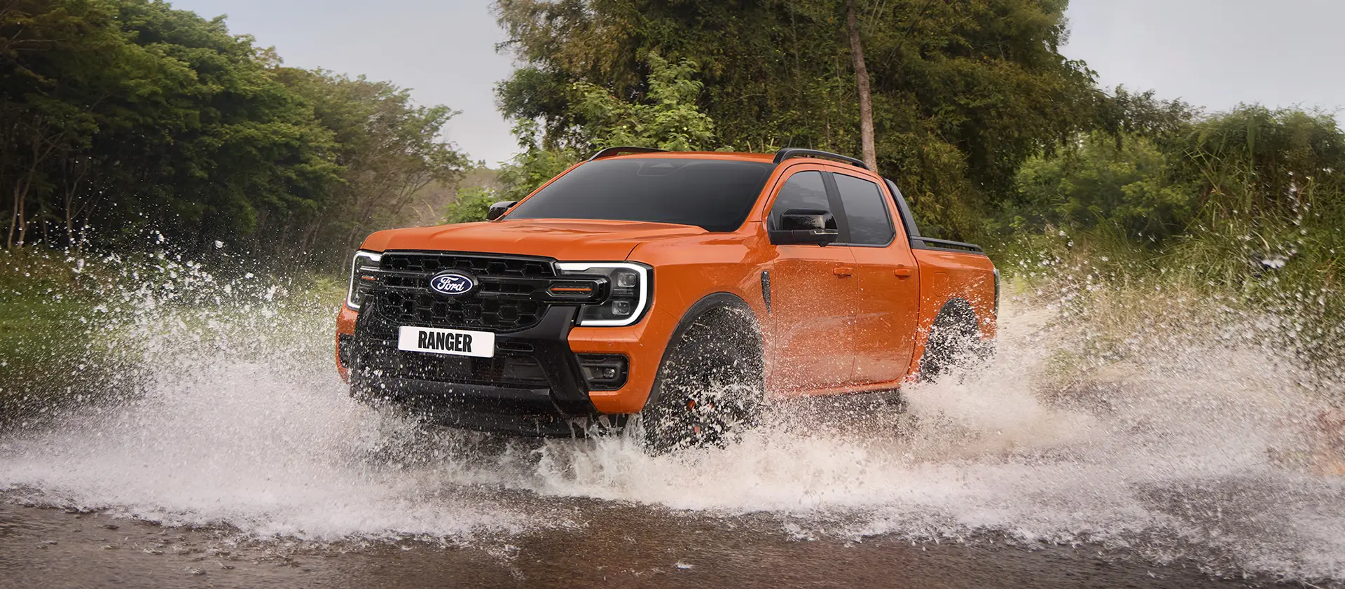 Orange Ford Ranger driving through water.