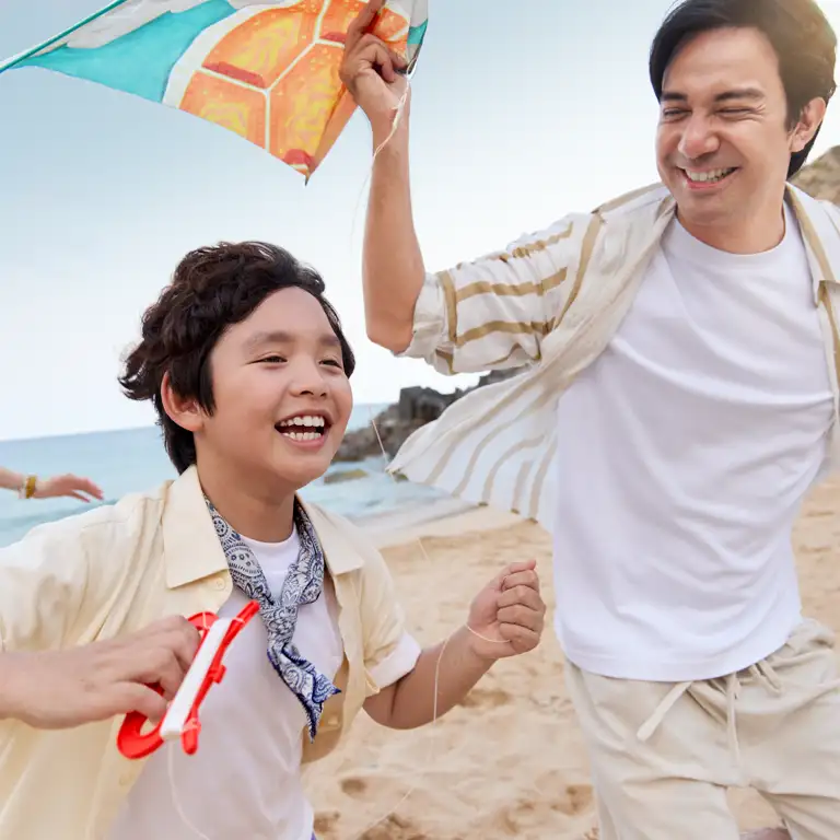 Family flying a kite on the beach